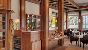 Una zona de bar con paneles de madera, una vinoteca y un comedor con mesas y sillas.