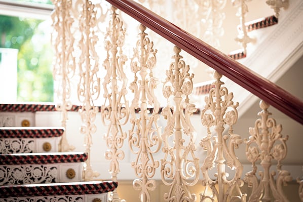 A staircase with ornate white railings and a wooden handrail.