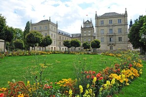 A large, historic building with a symmetrical facade, surrounded by a well-maintained garden with a variety of colorful flowers. - Best Western Blankenburg Hotel (Coburg)