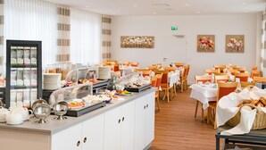 A buffet area with a variety of food items, a coffee station, and seating arrangements. - Best Western Blankenburg Hotel (Coburg)