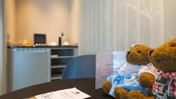 Una habitación con una mesa, un osito de peluche y un menú.