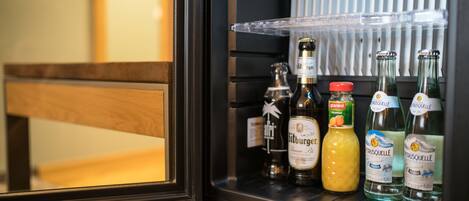 A minibar with various bottles of alcohol, including a bottle of Citrauselle and a bottle of orange juice.