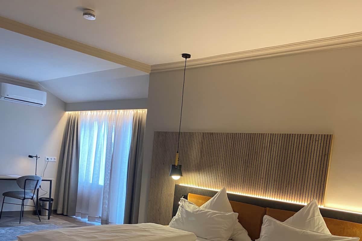 Una habitación de hotel con una cama grande, un escritorio y una silla.