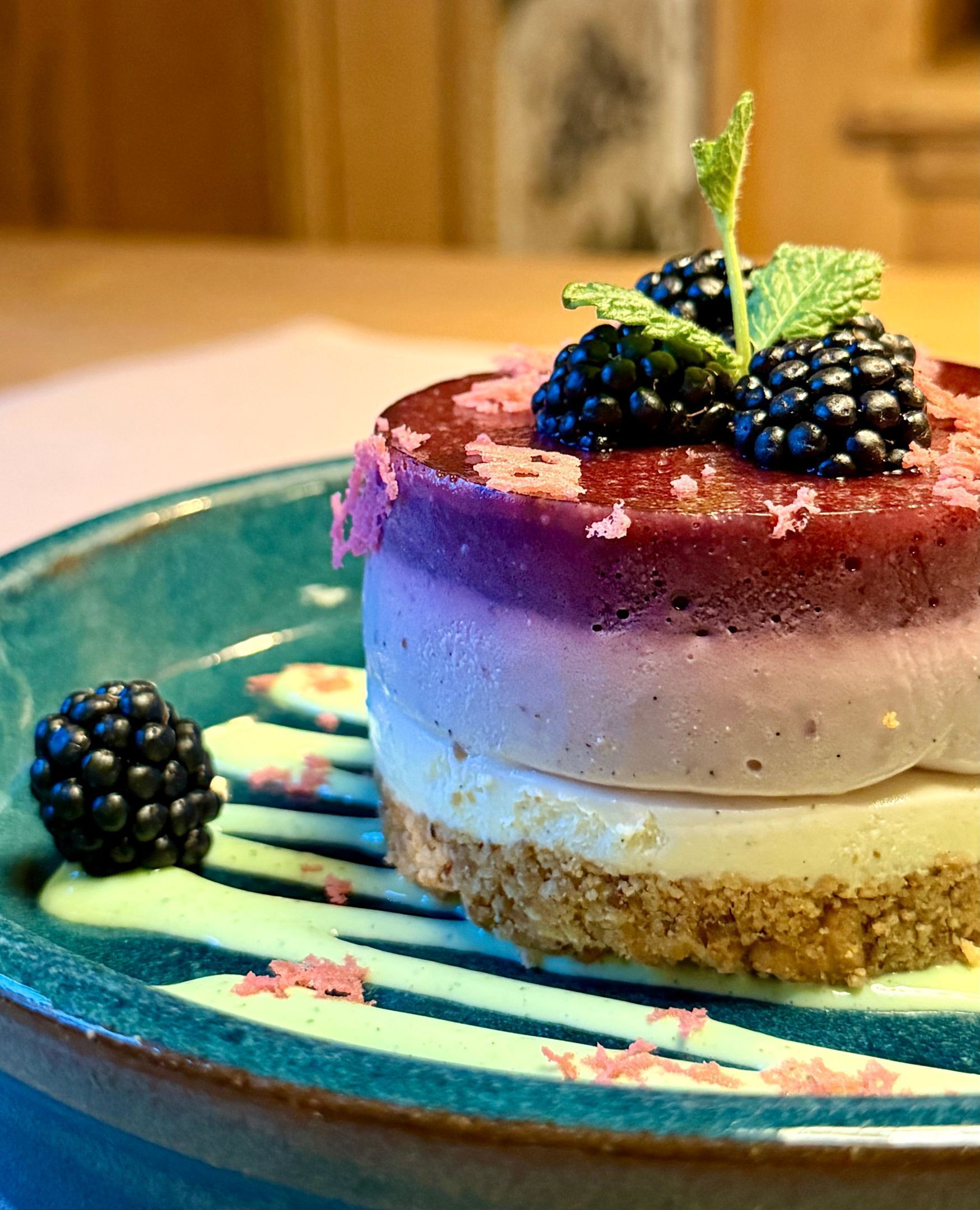 Un dessert composé de plusieurs couches, présenté dans une assiette et agrémenté d’une décoration.