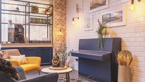 Una sala de estar moderna con un piano, una cafetera y una estantería.