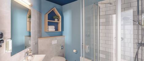 A bathroom with a shower, sink, and toilet.