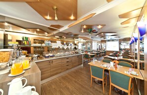 Un restaurante moderno con una isla central, múltiples mesas y diversas opciones de asiento.