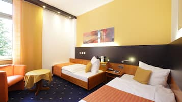 A hotel room with two beds, a sofa, a small table, and a painting on the wall.