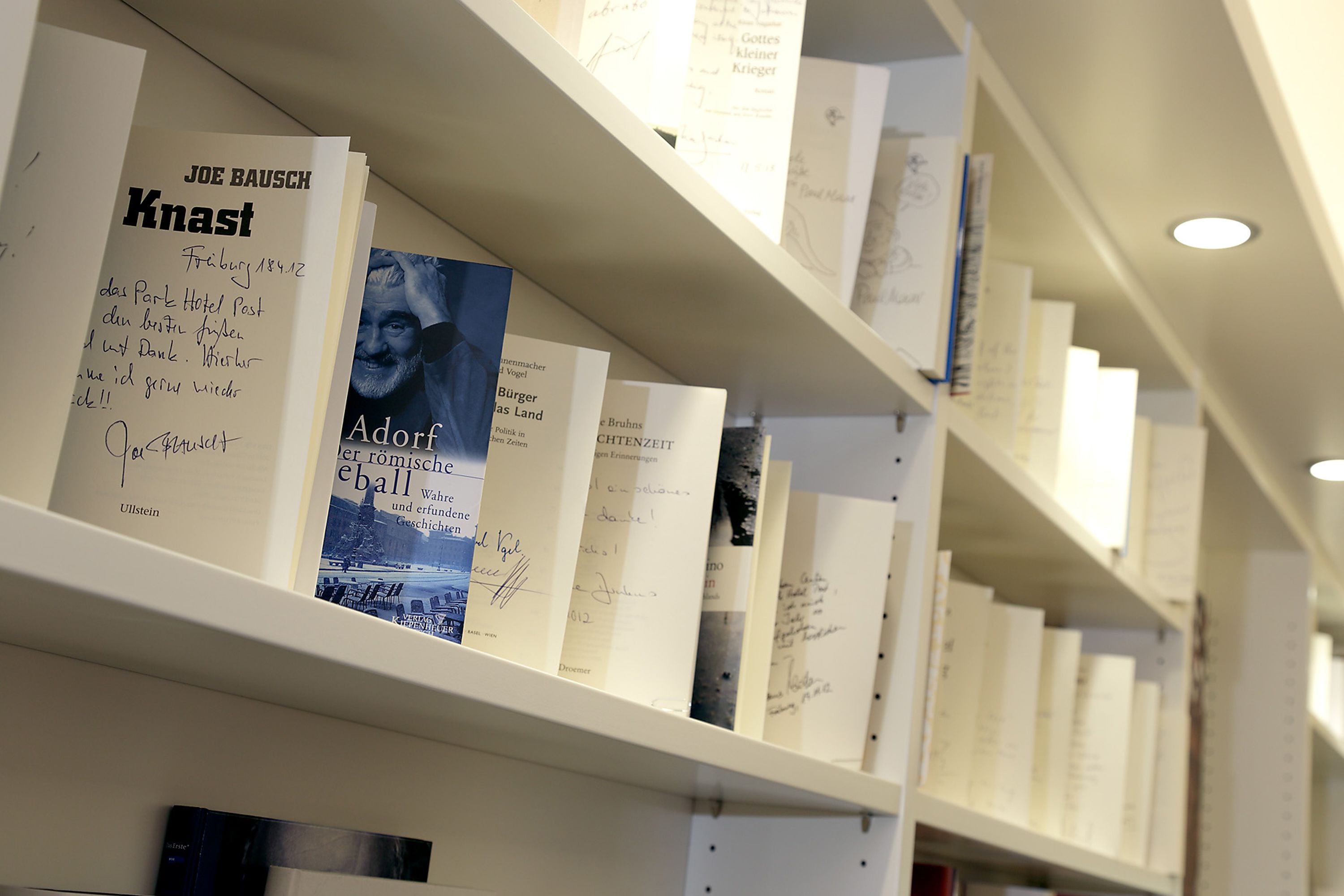 Ein Bücherregal mit verschiedenen Büchern, einige davon mit handschriftlichen Notizen.