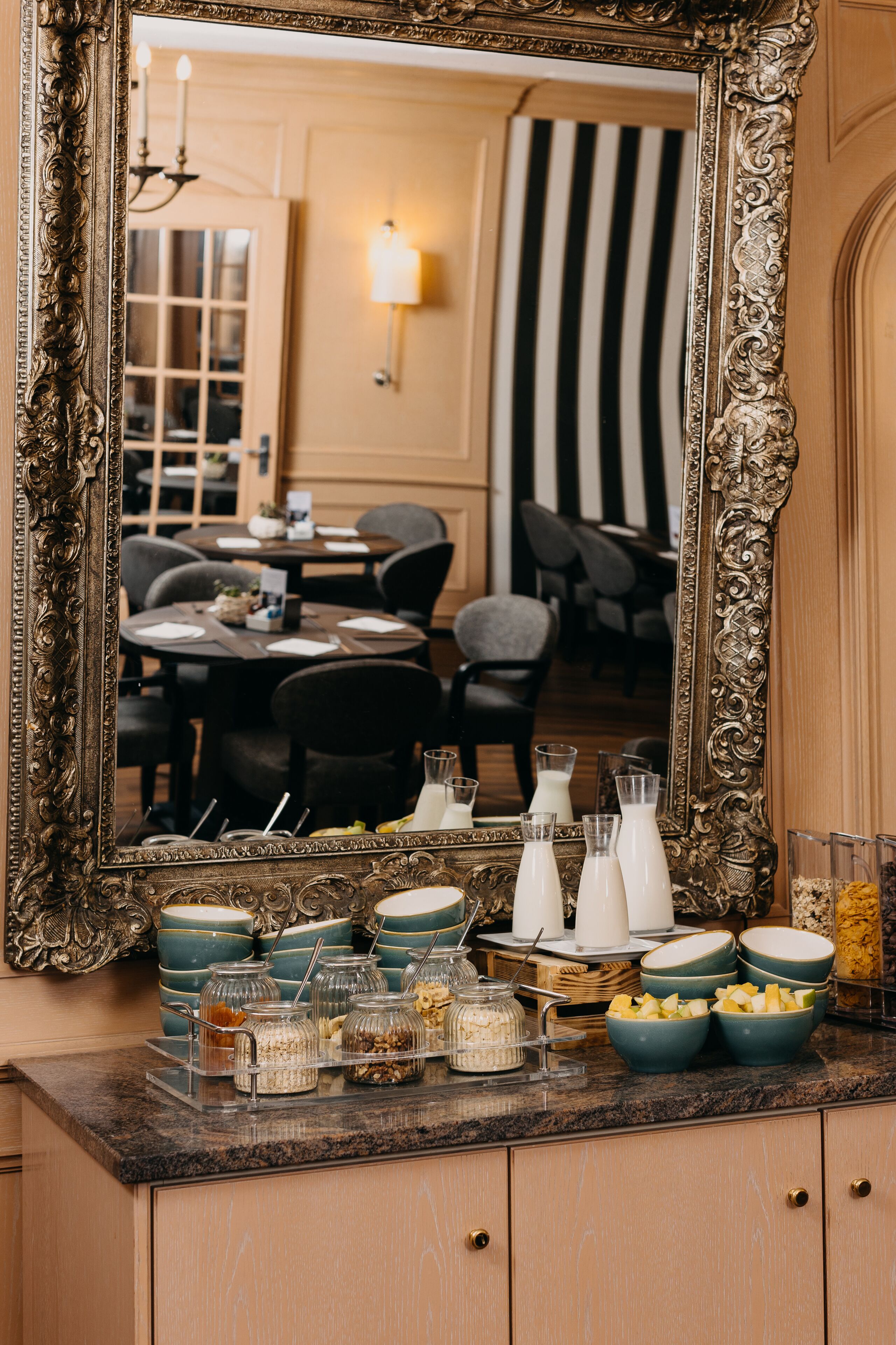 A mirror reflecting a dining area with a buffet setup.
