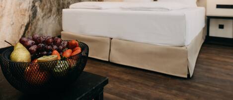 Una habitación de hotel con una cama, un frutero sobre una mesa y una pared de madera.