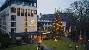 Un hotel con un letrero llamativo, un césped bien cuidado y un gran árbol de Navidad.