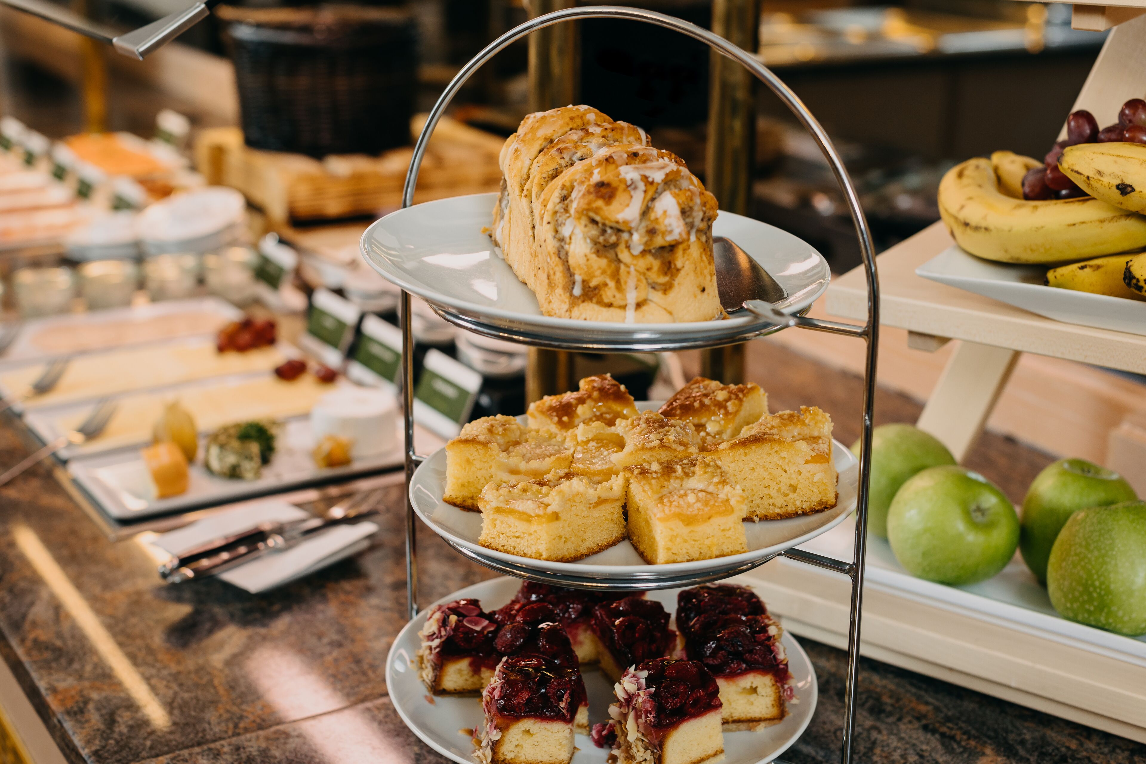 A buffet with various food items including cakes, pastries, and fruits.