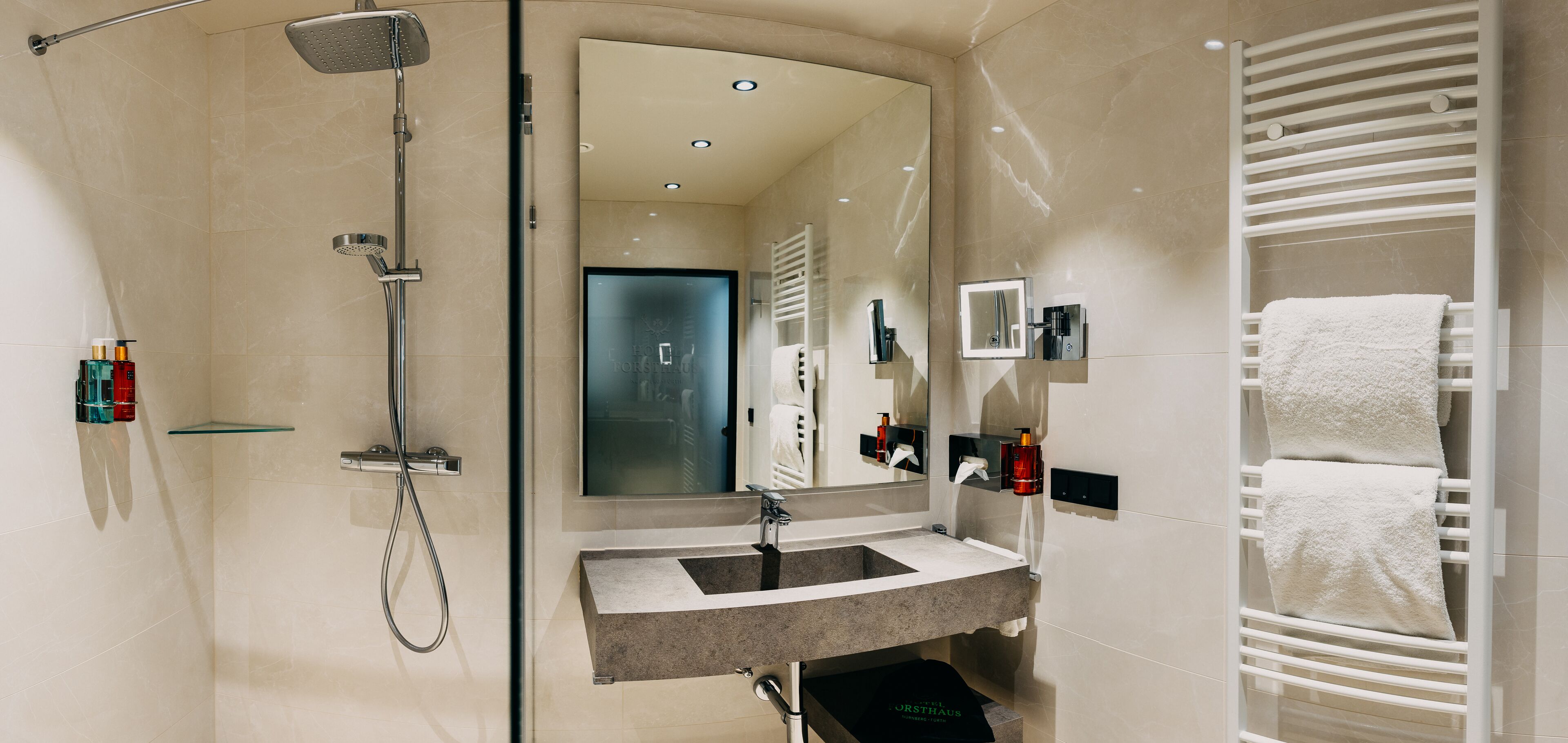 A modern bathroom with a glass-enclosed shower, a vanity with a sink, and a towel rack.