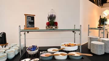 Disposição de buffet com diversos alimentos e utensílios.