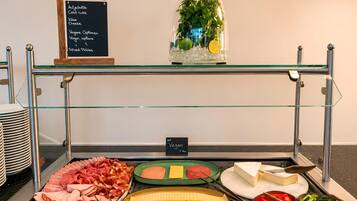 A buffet with various food options including meats, cheeses, and vegetables.