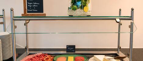A buffet with various food options including meats, cheeses, and vegetables.