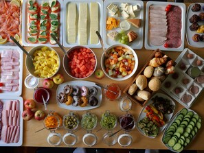A variety of food items including meats, cheeses, fruits, and pastries arranged on a table. - Hotel du Nord Alster (Hamburg)