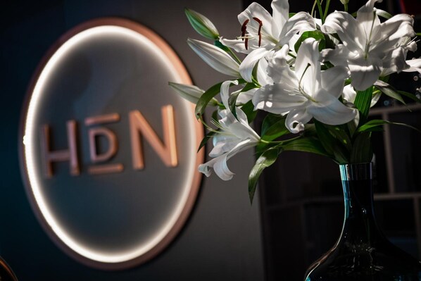 A logo with the letters "HDN" and a vase with white flowers. - Hotel du Nord Alster (Hamburg)
