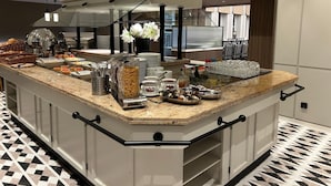 A modern kitchen with a central island, equipped with various food items and appliances. - Hotel Alster-Hof (Hamburg)