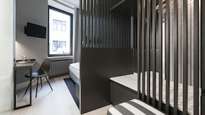 A modern hotel room with a bed, a desk, a chair, and a TV mounted on the wall. - Hotel Alster-Hof (Hamburg)