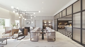 A modern interior with a dining area, seating arrangements, and a kitchen visible through a glass partition. - Hotel Alster-Hof (Hamburg)