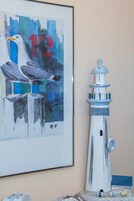 Un faro y un cuadro con gaviotas y el número 12.