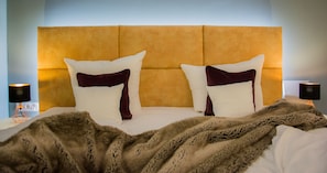 A bed with a headboard, two pillows, a blanket, and two bedside lamps. - Hotel Central Hof (Hof)