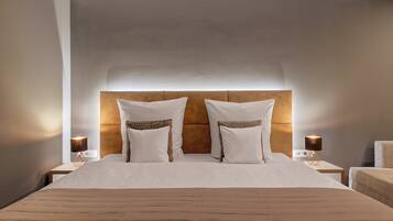 Habitación de hotel con una cama grande, dos mesitas de noche con lámparas y un cabecero.