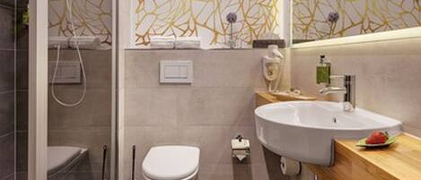 A modern bathroom with a glass shower enclosure, a toilet, and a sink with a wooden countertop.