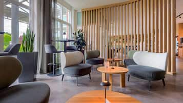 A modern lounge area with seating, a coffee table, and a wooden partition.