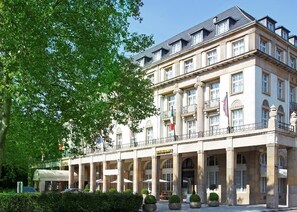 A historic building with multiple floors, a balcony, and a restaurant on the ground floor.