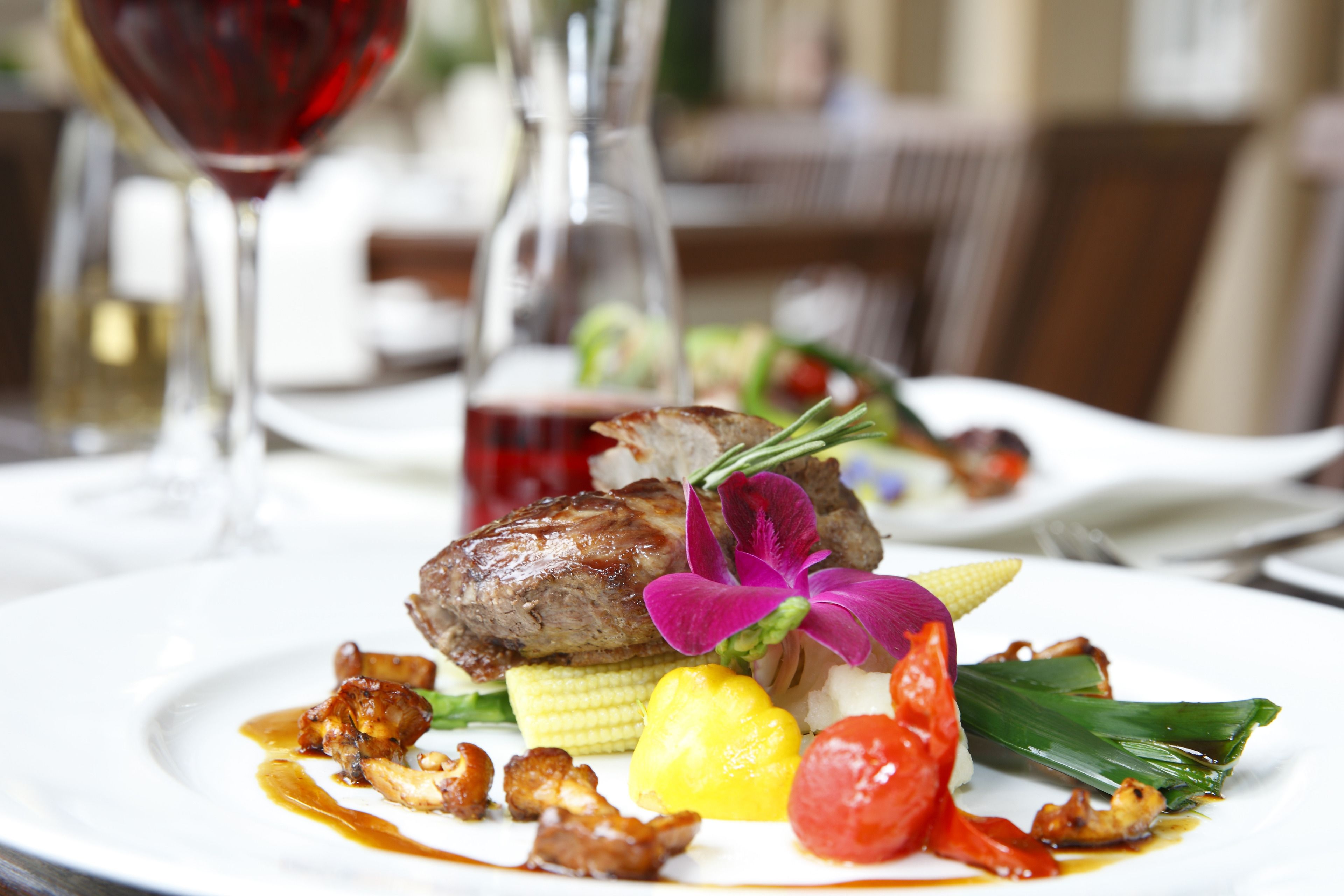 A plate of food with a steak, vegetables, and sauce.