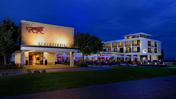 Un hotel con un llamativo logotipo de león, diseño moderno y una zona de entrada bien iluminada.