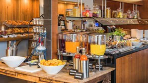 A buffet setup with various food items and beverages. - Hotel Wolfsburg Centrum, Affiliated by Meliá (Wolfsburg)