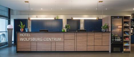 Una mesa de recepción de hotel con un letrero que dice "Hotel Wolfsburg Centrum".