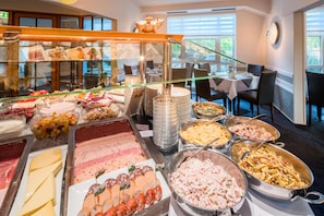 A buffet with various food options including meats, cheeses, and salads. - Best Western Hotel Windorf (Leipzig)