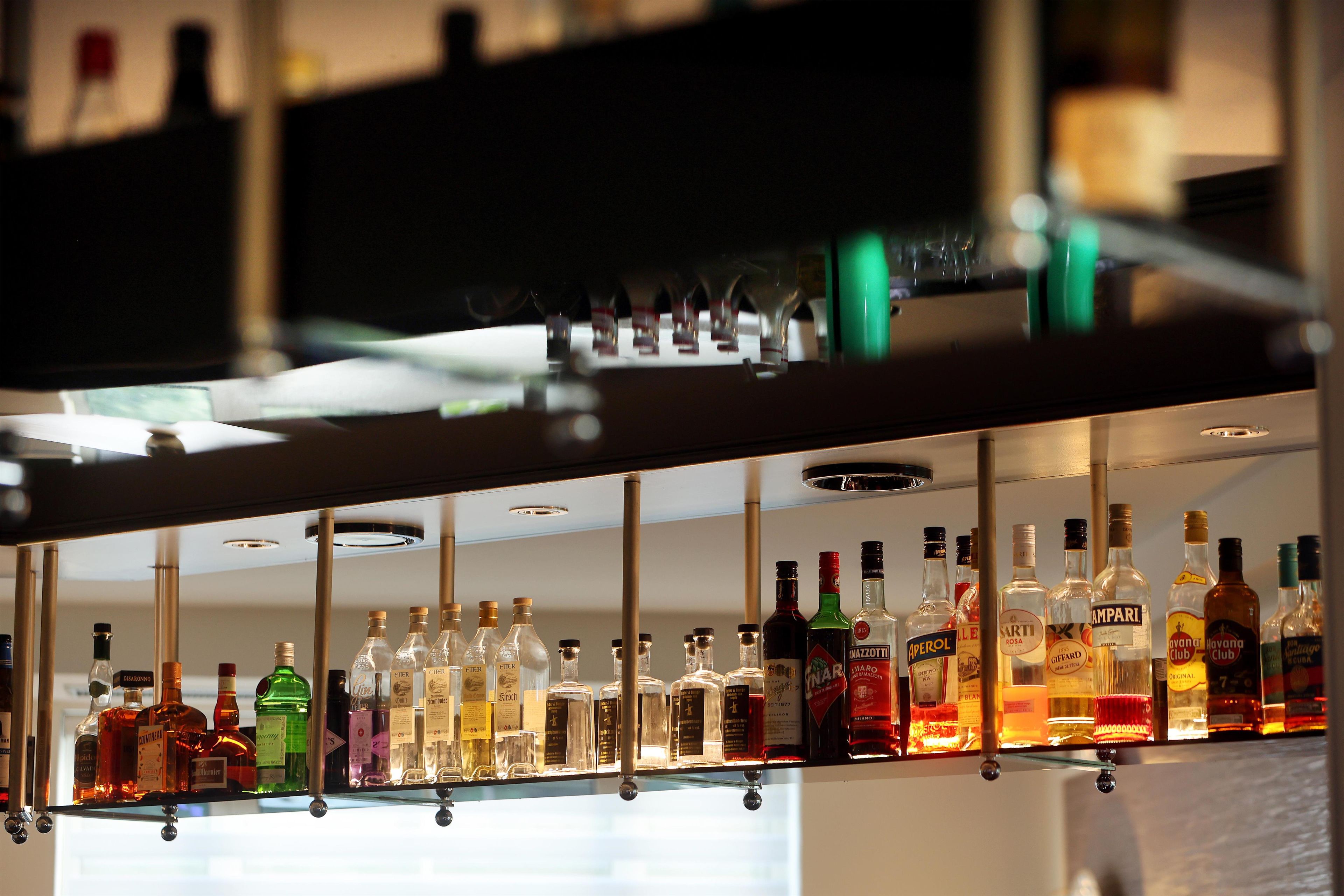Un bar con diversas botellas de licor en estantes.