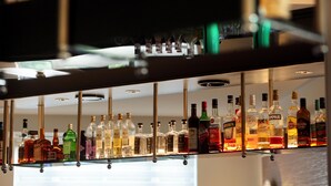 Un bar con diversas botellas de licor en estantes.