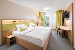 A hotel room with a large bed, a desk, a chair, a television, and a window with curtains. - Best Western Hotel Windorf (Leipzig)