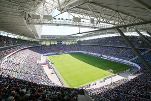 A large stadium with multiple tiers of seating, a central field, and a covered upper section. - Best Western Hotel Windorf (Leipzig)
