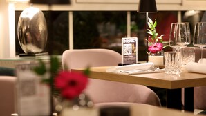 A restaurant table set with wine glasses, a candle, and a QR code sign. - Best Western Hotel Windorf (Leipzig)