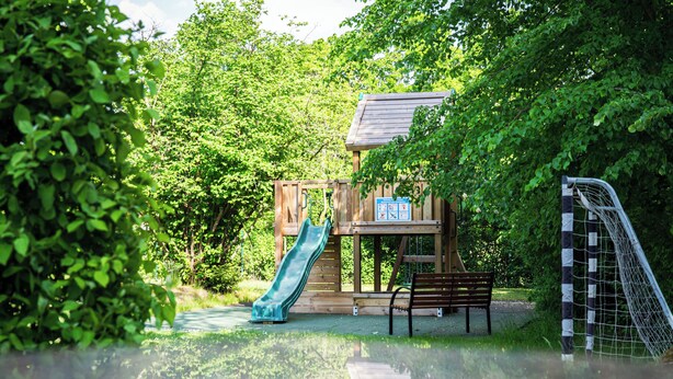 A playground with a slide, a bench, and a soccer goal. - Best Western Hotel Windorf (Leipzig)