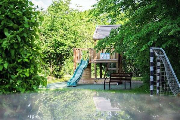 A playground with a slide, a bench, and a soccer goal. - Best Western Hotel Windorf (Leipzig)