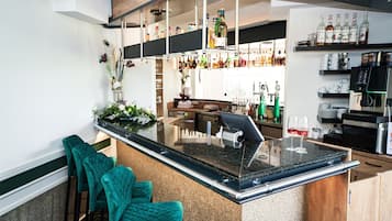 Eine Bar mit Theke, Sitzgelegenheiten und einer Auswahl an Flaschen.