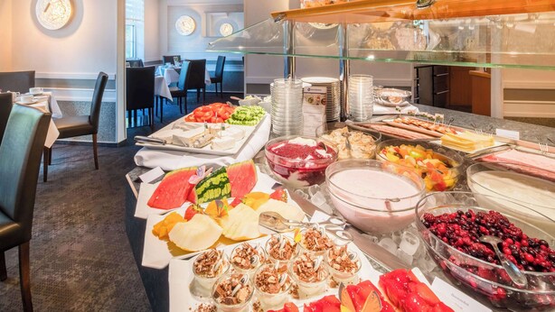 A buffet with various food items and a glass display case. - Best Western Hotel Windorf (Leipzig)