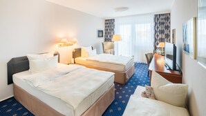 A hotel room with two beds, a desk, a chair, a television, and a window with curtains. - Best Western Hotel Windorf (Leipzig)