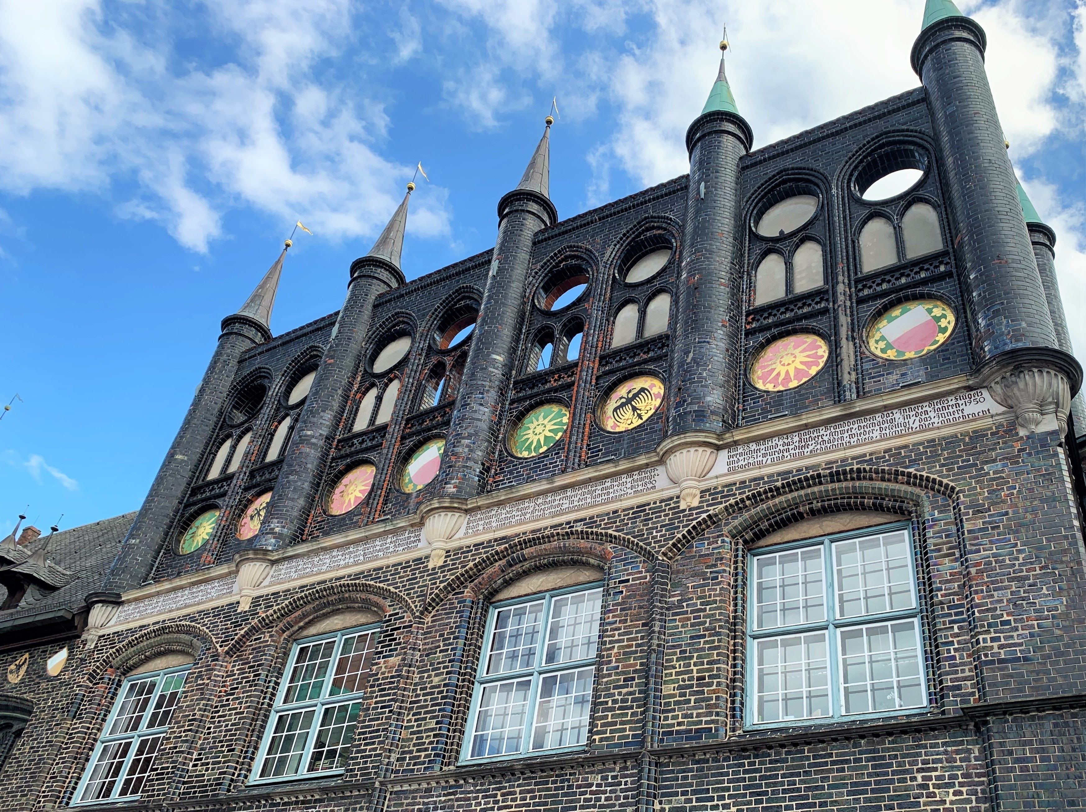 Ein historisches Gebäude mit zahlreichen Rundbogenfenstern und einem Turm mit einer Spitze.