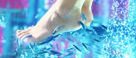 A foot submerged in water with fish swimming around.