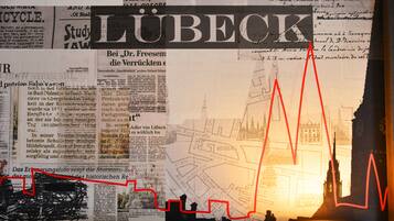 A wall with various newspaper clippings and a map, with the word "Lübeck" prominently displayed.